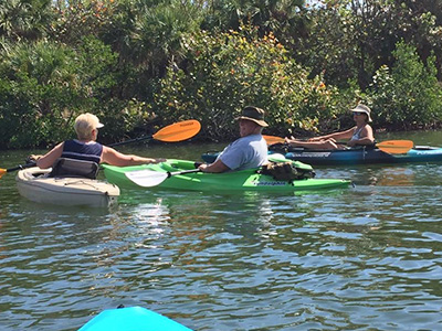 Active adults in our community posing with kayak and paddles.